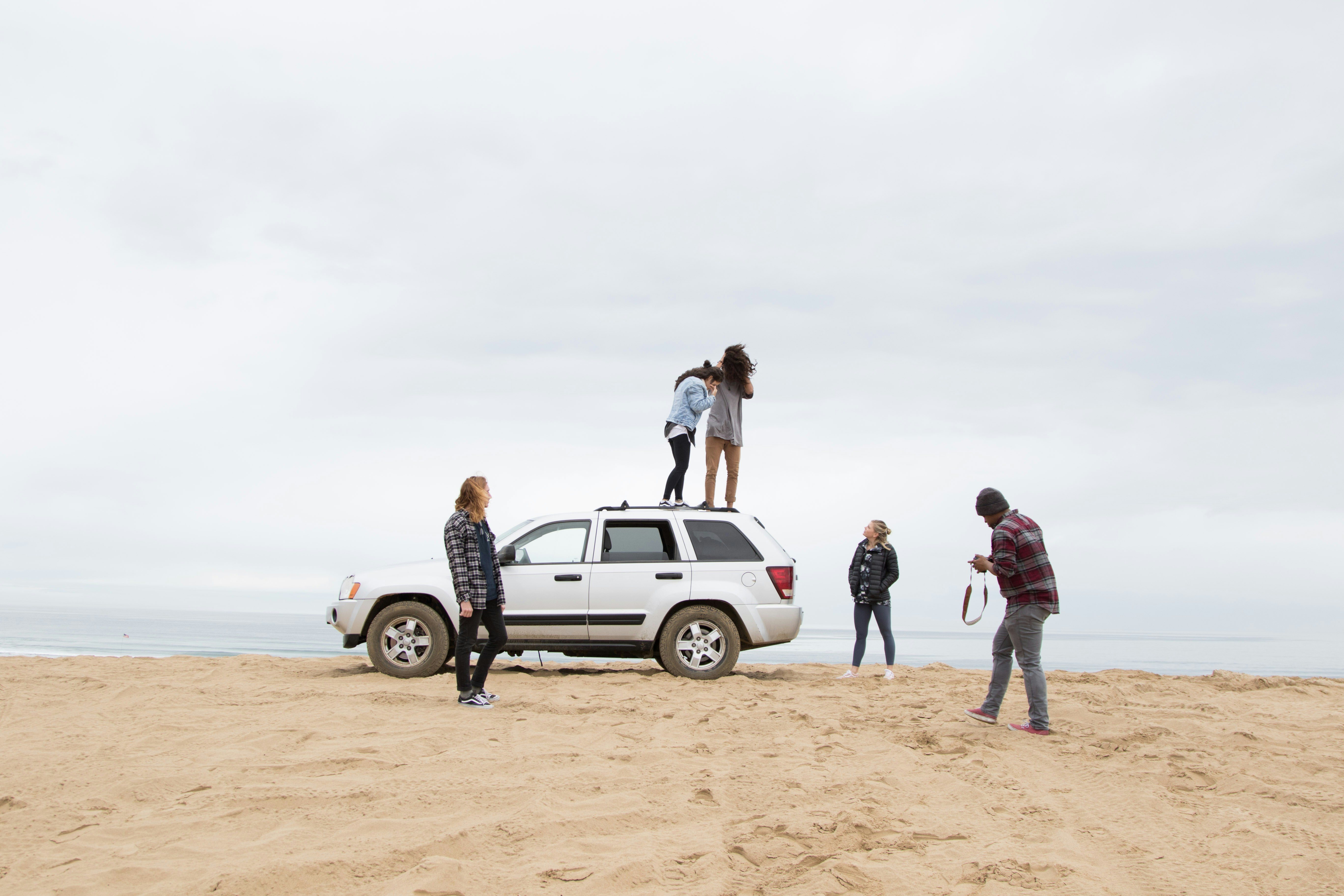 friends posing around a car